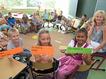Georg, Melina und Angelina (v.l.) zeigen die Kärtchen, mit denen Lehrerin Andrea Müller die Kinder der 2b an die englische Sprache heranführt. Foto: Ronald Rinklef