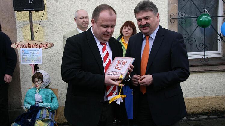 23. März 2010: Landrat Klaus Peter Söllner (rechts) hatte zur Geschäftseröffnung ein Landkreiswappen für Werner Burger (vorne, links) mitgebracht, im Hintergrund Dorfladen-Geschäftsführer Michael Laaber und Marktleiterin Irmgard Raupach. Foto: Archiv