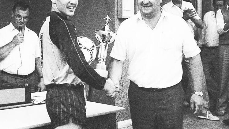 Die Siegerehrung beim Raiffeisen-Pokal der A-Jugend nimmt Eduard Reis von der Raiffeisenbank Oberthulba vor. Er überreicht den Pokal an den Spielführer der SG Hassenbach/Schlimpfhof, Karl-Heinz Morbitzer.