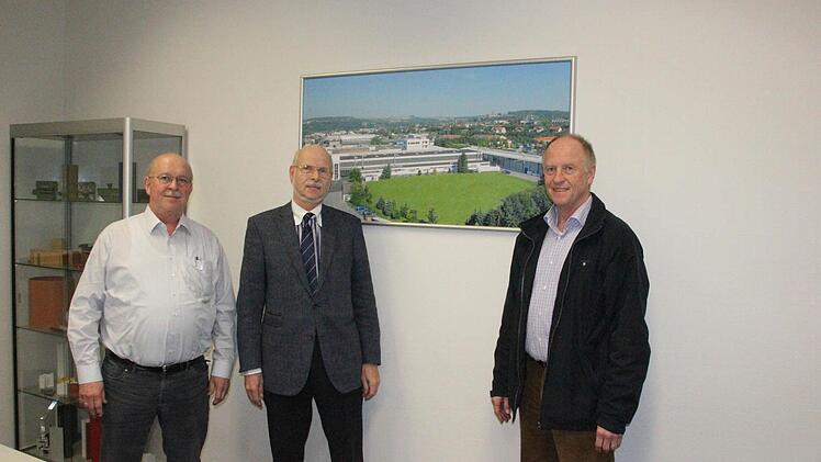 Die Brüder Michael, Johannes und Georg Weber (von links) vor einem Foto des Werks II in der Industriestraße in Kronach. Johannes Weber zeigt auf das Areal, auf dem der Neubau entstehen soll.  Foto: Friedwald Schedel