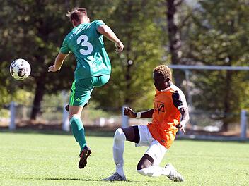 Jonas B&auml;uerlein (gr&uuml;nes Trikot) schl&auml;gt den Ball vor dem Kleintettauer Omar Gassama weg.