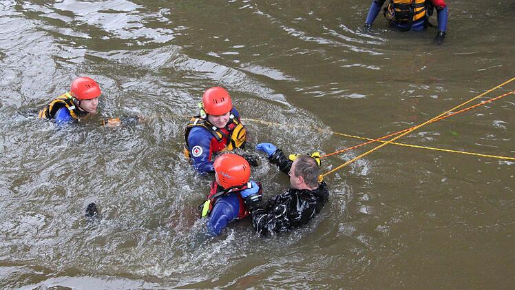 Die mit Leinen gesicherten Retter fangen den im Wasser treibenden "Verunglückten" auf.