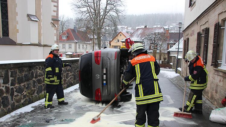 Die Feuerwehr Steinwiesen kehrt das Bindemittel zusammen. Foto: Andreas Schmitt