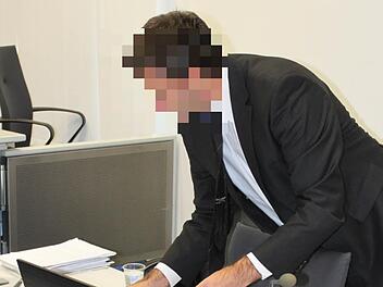 Der Angeklagte Heinz W. klappt vor Gericht sein Notebook auf.