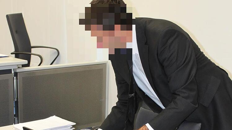 Der Angeklagte Heinz W. klappt vor Gericht sein Notebook auf.