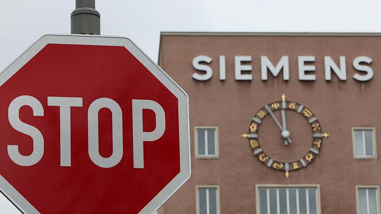 Die Uhr am Siemens-Zentralgebäude in Erlangen zeigt Fünf vor Zwölf. Derzeit ist noch unklar, inwieweit der Stellenabbau im Konzern weitergehen soll. Foto: Daniel Karmann/dpa/Archiv