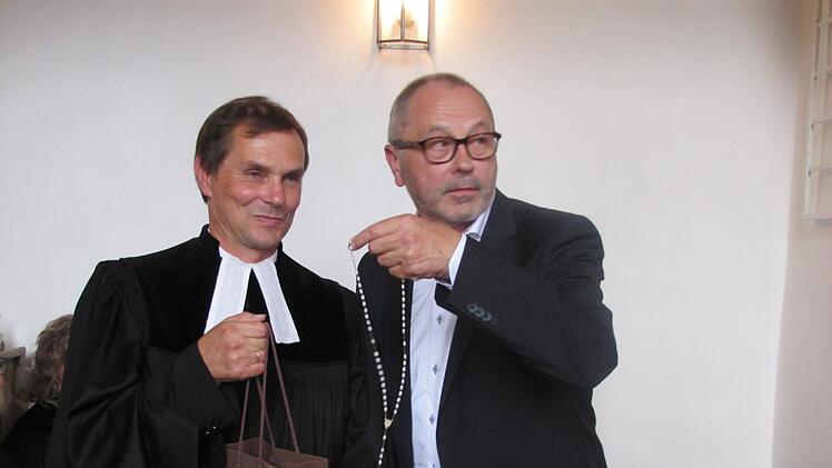Kirchenpfleger Prof. Helmuth Kollo vom katholischen Seelsorgebereich Coburg Stadt und Land schenkt Pfarrer Klaus Göpfert zum Abschied einen Rosenkranz. Dieses Gebetsutensil wird ja an seinem neuen Wirkungsort in Altötting ja häufig verwendet ... nur eben noch nicht bei den Altöttinger Protestanten. Foto: Martin Koch