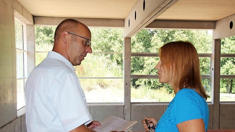 Bürgermeister Gerd Kleinhenz und Schulleiterin Christiane Helfrich begutachten den Baufortschritt von der Galerie der Turnhalle aus.