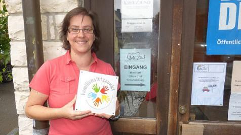 Barbara Großmann mit dem Schild Familienstützpunkt