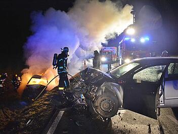 Ein Bild des Grauens an der Unfallstelle: Der Unfall verursachende Pkw stand quer zur Straße, unterhalb der Böschung löschten Feuerwehrleute das Auto, in dem Beifahrerin und Fahrerin verbrannten. Foto: Hanns Friedrich