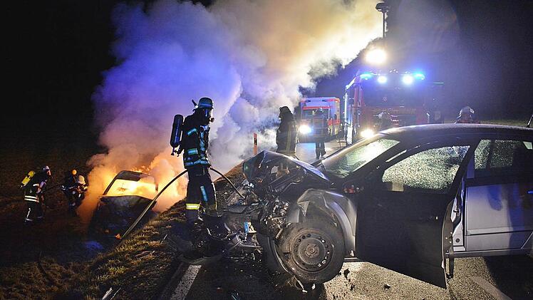 Ein Bild des Grauens an der Unfallstelle: Der Unfall verursachende Pkw stand quer zur Straße, unterhalb der Böschung löschten Feuerwehrleute das Auto, in dem Beifahrerin und Fahrerin verbrannten. Foto: Hanns Friedrich