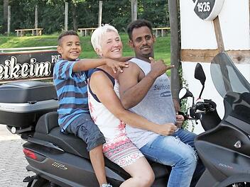 Efani, Mathilde Jäger und Abdul (von links) wollen den Roller am liebsten gleich zusammen ausprobieren. Foto: Roland Dietz