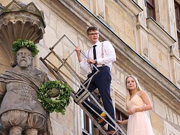 Alljährlich ehrt das Coburger Gymnasium Casimirianum seinen Gründer, indem es die Statue an der Schule bekränzt. Simon Stürzebecher und Anna Oikonomides auf der Leiter. Foto: Simone Bastian
