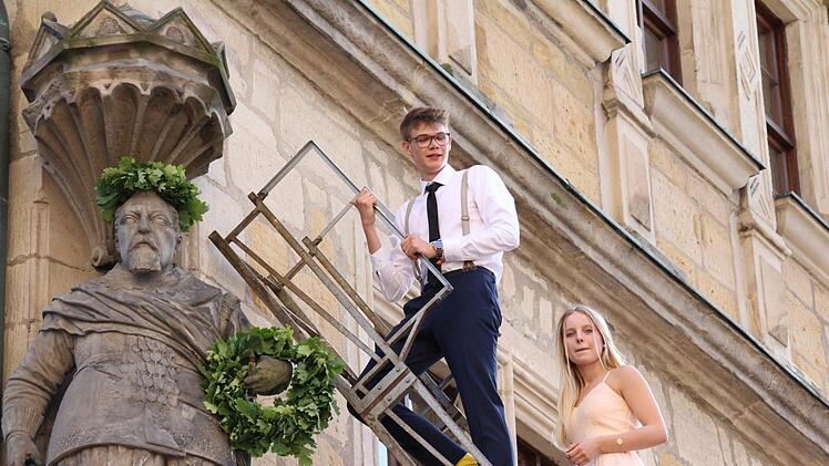 Alljährlich ehrt das Coburger Gymnasium Casimirianum seinen Gründer, indem es die Statue an der Schule bekränzt. Simon Stürzebecher und Anna Oikonomides auf der Leiter. Foto: Simone Bastian