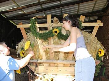 Gerlinde und Sophia Gopp schmücken den Erntewagen, der beim Heimatspiel zum Einsatz kommt. Foto: Heike Beudert