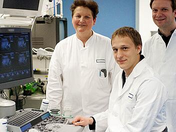 Ferdinand Knieling (sitzend) mit Deike Strobel (Leiterin der Ultraschallabteilung, Medizinische Klinik 1 - Universität Erlangen Nürnberg, Doktormutter) und Maximilian Waldner (Betreuer der Doktorarbeit). Das Bild wurde in der Ultraschallabteilung aufgenommen. Foto: privat