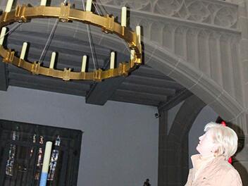 Kirchenverwaltungsmitglied Brigitte Wolf unter dem Leuchter, den die Herz-Jesu-Kirche im Rahmen der Innensanierung erhielt. Foto: Mäuser
