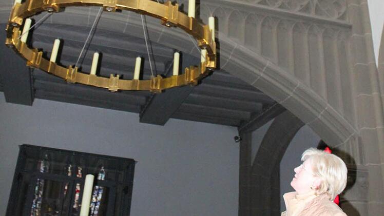 Kirchenverwaltungsmitglied Brigitte Wolf unter dem Leuchter, den die Herz-Jesu-Kirche im Rahmen der Innensanierung erhielt. Foto: Mäuser