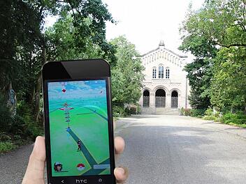 Zu erkennen sind im Display der Hauptweg zum Mausoleum, der von der Straße Hinterer Glockenberg abzweigt. Das Gebilde am Ende des Weges stellt eine Arena dar. Hier können die Mitglieder des roten Teams ihre Pokémon trainieren oder gegen die Pokémon der Teams Gelb und Blau kämpfen. Fotos: Simone Bastian, Montage: Dagmar Klumb