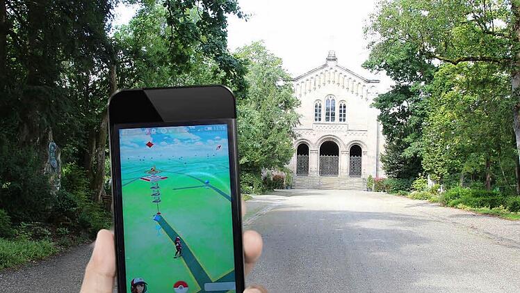 Zu erkennen sind im Display der Hauptweg zum Mausoleum, der von der Straße Hinterer Glockenberg abzweigt. Das Gebilde am Ende des Weges stellt eine Arena dar. Hier können die Mitglieder des roten Teams ihre Pokémon trainieren oder gegen die Pokémon der Teams Gelb und Blau kämpfen. Fotos: Simone Bastian, Montage: Dagmar Klumb