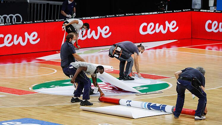 Zehn Helfer bauen zwischen den beiden Spielen um: Hier wird gerade die Parkett-Werbung auf die neue "Heimmannschaft" angepasst. Foto: Daniel Löb/Pool