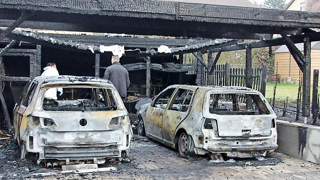 Zwei VW Golf brannten in dem Carport in der Ermershäuser Hauptstraße mit aus. Auch der Zaun zum Nachbaranwesen ging in Flammen auf. Am Dienstagmorgen waren Brandermittler der Kripo Schweinfurt damit beschäftigt, die Brandursache ausfindig zu machen.  Foto: Ralf Kestel