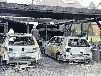 Zwei VW Golf brannten in dem Carport in der Ermersh&auml;user Hauptstra&szlig;e mit aus. Auch der Zaun zum Nachbaranwesen ging in Flammen auf. Am Dienstagmorgen waren Brandermittler der Kripo Schweinfurt damit besch&auml;ftigt, die Brandursache ausfindig zu machen.  Foto: Ralf Kestel