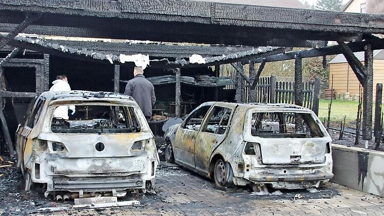 Zwei VW Golf brannten in dem Carport in der Ermershäuser Hauptstraße mit aus. Auch der Zaun zum Nachbaranwesen ging in Flammen auf. Am Dienstagmorgen waren Brandermittler der Kripo Schweinfurt damit beschäftigt, die Brandursache ausfindig zu machen.  Foto: Ralf Kestel