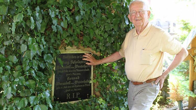 Werner Eberth am Grab von Conrad Morandell von Westerhofen, einem ehemaligen Distriktstechniker (heute würde er Kreisbaumeister genannt). Der Efeu hat dem Grab schon schwer zugesetzt. Foto: Thomas Ahnert