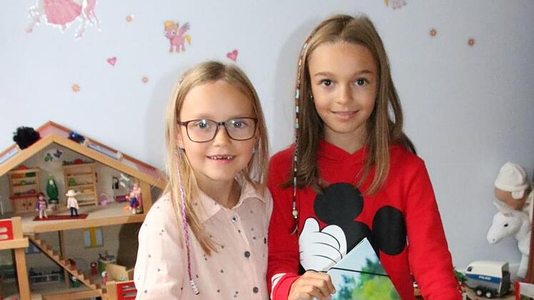 Gut, eine ältere Schwester zu haben: Die neunjährige Lena (rechts) hilft ihrer sechsjährigen Schwester Viktoria nicht nur beim Packen der Büchertasche, sondern gibt auch Tipps zum Schul-Alltag. Foto: Ralf Ruppert