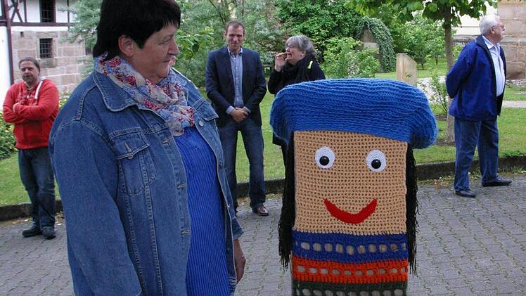 Selbst die Erinnerung an die Goldmedaille im Wettbewerb "Unser Dorf soll schöner werden" ist unter Strickkleid und Mütze verschwunden, wie Christa Fischer (links) überrascht feststellt. Foto: Bettina Knauth