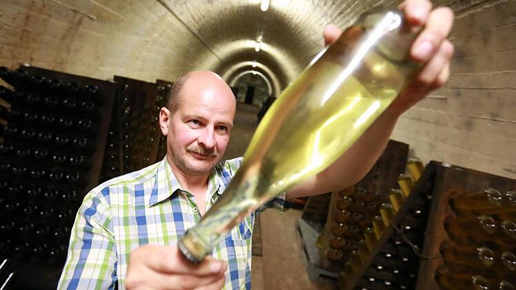 Der Sekt in der Flasche, die Martin Fischer prüft, ist klar. Die Hefepartikel haben sich innen auf dem Verschluss abgesetzt. Damit das passiert, lagert der Winzer seinen Sekt kopfüber in dem Stollen im Ebelsberg. Fotos: Hendrik Steffens