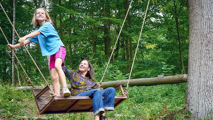 Anne (Meret Becker, rechts) und ihre Enkelin Tilda (Luise Landau) probieren die Schaukel in Annes Wald aus, den sie von ihrem jung verstorbenen Mann geerbt hat. In der Gemeinde ist Anne auch deshalb Außenseiterin, weil die anderen Bewohner dort anstatt von Bäumen gerne ein lukratives Bauprojekt gesehen hätten.