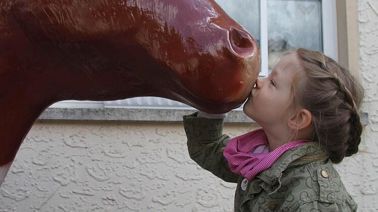 Mina Hornig (4) würde am liebsten eine Kuh als Haustier mit nach Hause nehmen und küsst die Plastikkuh. Foto: Sonja Adam