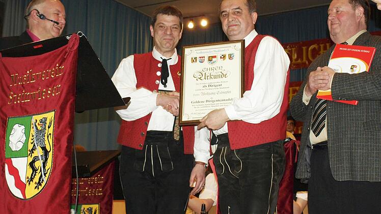Stolz überreicht stellv. Bezirksvorsitzender Thomas Kolb (Mitte rechts) die Urkunde für 25 Jahre Dirigent an Wolfgang Schrepfer (links).