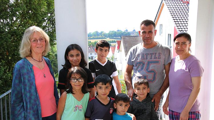Khalel Qaisar mit seiner Frau und seinen sechs Kindern in der dezentralen Unterkunft in Memmelsdorf. Heidemarie Groß (links) kümmert sich als ehrenamtliche Helferin um die Integration.  Khalel Qaisar nimmt an einer Umschulung zum Staplerfahrer teil.  Foto: Sebastian Schanz