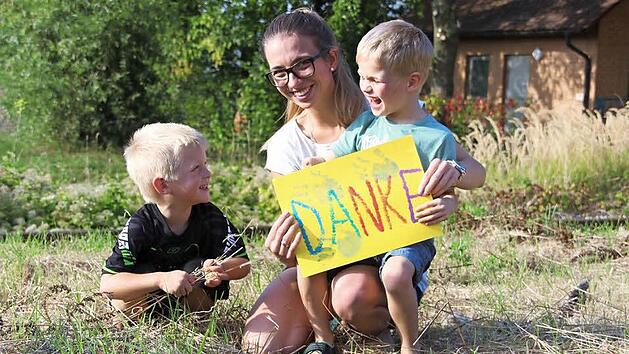 Zusammen mit Mutter Michaela Geisel und Bruder Lenny hat der sechsj&auml;hrige Luca (rechts) ein Plakat f&uuml;r alle Helfer gebastelt.  Foto: Sarah Stieranka