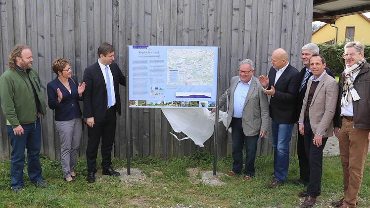 Eine Tafel zum Rundwanderweg "Kopfeichenland" wird enthüllt (v.l.): Leo Anwander (Projektleiter), Anja Gebhardt (Landschaftspflegeverband), Landrat Hermann Ulm, Franz Schmidtlein (Bürgermeister Hetzles), Claus Schwarzmann, Hermann Greif (beide Landschaftspflegeverband), MdL Torsten Glauber und Heinz Richter (Bürgermeister Neunkirchen). Foto: Franz Galster