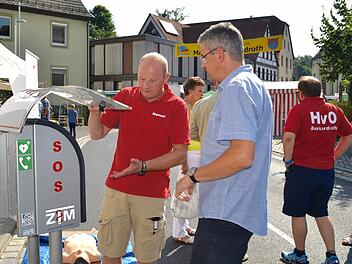Beim Frühjahrsmarkt 2016 wurde der Defibrillator öffentlich vorgestellt. Inzwischen ist dieser im Schalterraum der Raiffeisenbank montiert. Hier erläutert der Rettungssanitäter Manuel Vorndran Gemeinderat Michael Frank dessen Funktionsweise.  Foto: Kathrin Kupka-Hahn