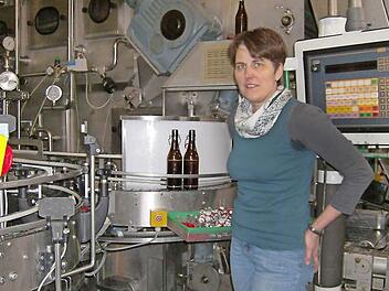 Irene Brehmer-Stockum, Chefin der Brauerei und selbst Brauerin, vor dem Förderband, auf dem die leeren Flaschen nach den Spülgängen zur Kontrolle befördert werden. Foto: Petra Malbrich