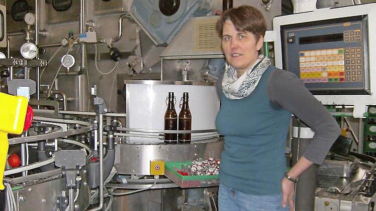 Irene Brehmer-Stockum, Chefin der Brauerei und selbst Brauerin, vor dem Förderband, auf dem die leeren Flaschen nach den Spülgängen zur Kontrolle befördert werden. Foto: Petra Malbrich
