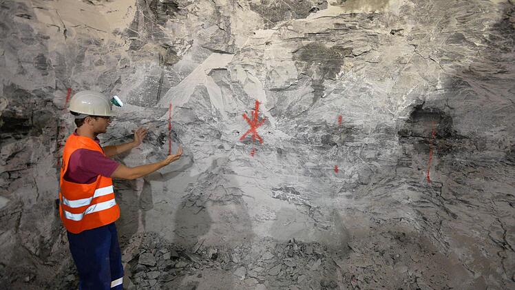 Betriebsingenieur Jens Reimer erklärt die Vorgehensweise: 45 Millimeter breite und drei Meter tiefe Löcher werden im Abstand von 1,20 Meter gebohrt. In ihnen stecken später die Sprengladungen. Foto: Ronald Rinklef