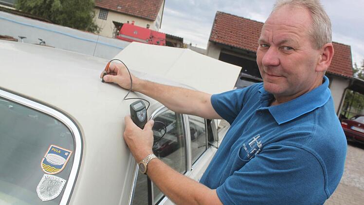 Hans Limpert misst mit einem Spezialgerät die Dicke des Lacks. Foto: Matthias Einwag