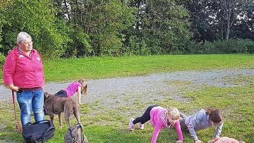 Hildegard Havenith und "Spürhund Abbey" mit einigen Kindern beim Erfüllen der Aufgabe: zehn Liegestützen!