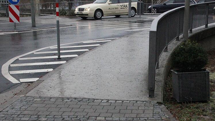 NACHHER: Seit knapp vier Monaten hat der Blumenkübel an der Pfählangerstraße keinen richtigen Platz mehr. Während des Schützenfestes wurde er von Vandalen direkt auf die Fahrbahn gestellt. Das behinderte die Autofahrer. Anschließend wanderte er von der Sperrfläche direkt auf den Gehsteig. Menschen mit Kinderwagen oder Rollator hatten es sehr schwer, daran vorbeizukommen. Mittlerweile steht der Kübel seitlich daneben. Foto: Vanessa Schneider