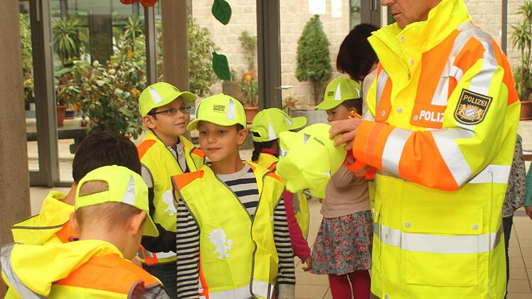 Verkehrspolizist Stefan Scherrer bei der Übergabe der Westen und Mützen.Foto: Günther Geiling