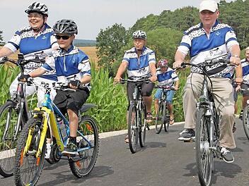 Eine Gruppe des Radfahrvereins Viktoria Maineck radelt auf dem frisch geteerten Weg zur Einweihung.  Foto: Stephan Stöckel