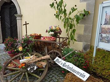Der geplünderte Erntedankwagen des Stockheimer Obst- und Gartenbauvereins vor dem Gotteshaus St. Wolfgang. Daneben der Infokasten mit Bildern vom Sonntag.  Foto: Gerd Fleischmann