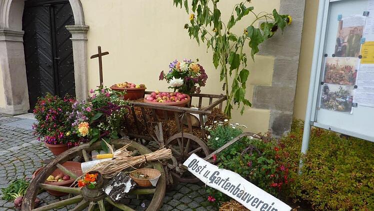 Der geplünderte Erntedankwagen des Stockheimer Obst- und Gartenbauvereins vor dem Gotteshaus St. Wolfgang. Daneben der Infokasten mit Bildern vom Sonntag.  Foto: Gerd Fleischmann
