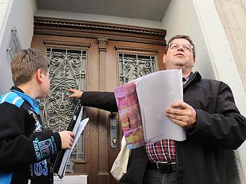 Erich Olbrich und sein Enkel Marcus erläutern, was es mit dem aufwendig getalteten Gitter am Stammhaus der Familie Ruckdeschel auf sich hat.  Fotos: Matthias Hoch